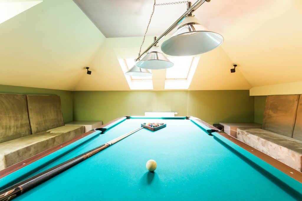 Entertainment attic room with a billiard table